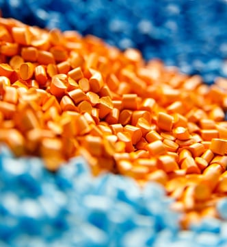 light blue, dark blue, and orange plastic injection molding resin pellets